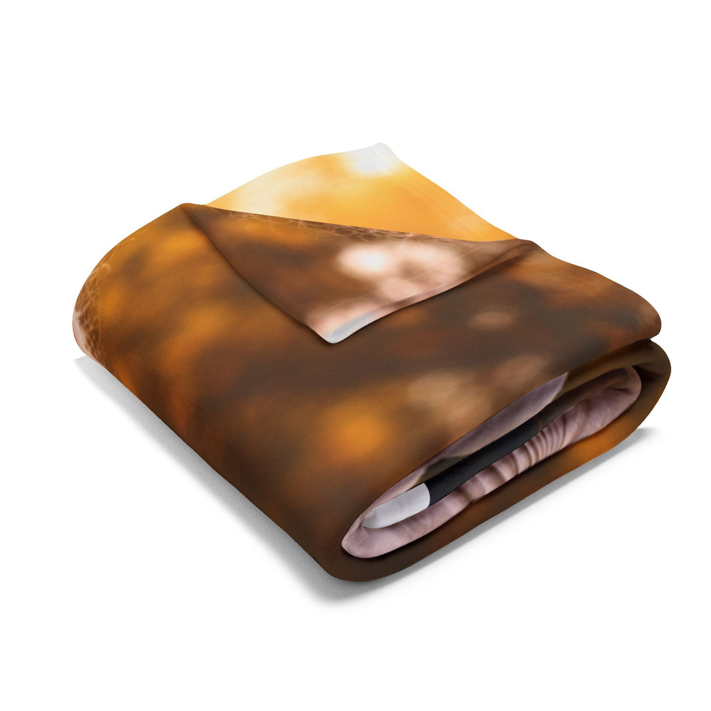 Folded blanket with a nature-themed design on a white background